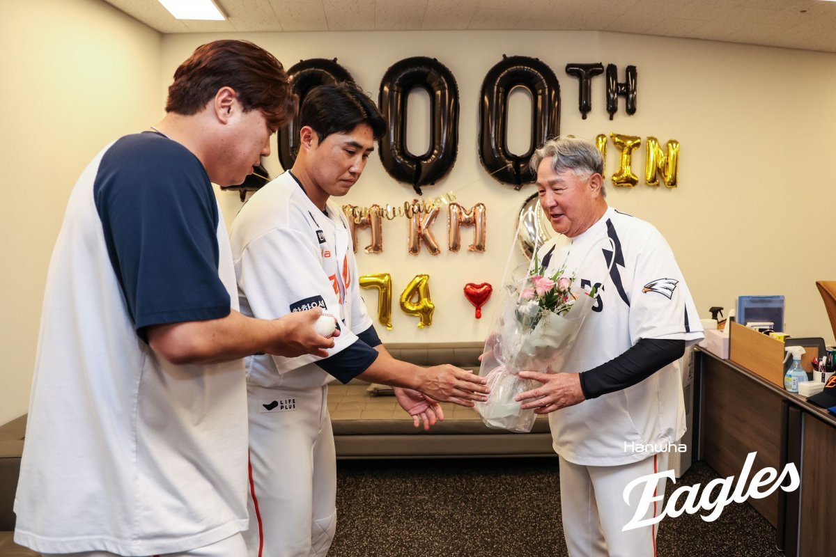 한화 김경문 감독(오른쪽)이 12일 대전 롯데전에서 개인 통산 1000승을 달성한 뒤 류현진(왼쪽)과 채은성으로부터 기념구와 꽃다발을 받고 있다. 사진제공|한화 이글스