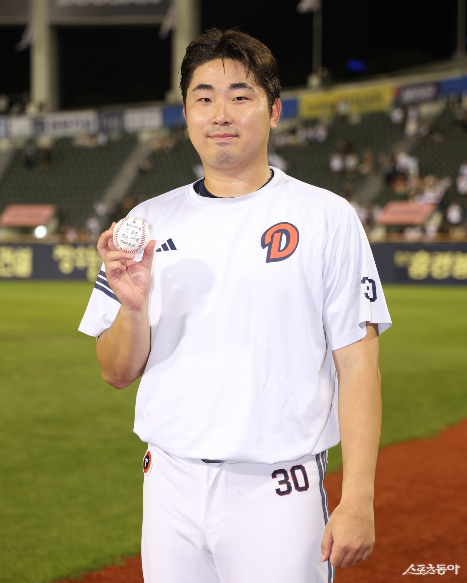두산 김정우가 16일 잠실구장에서 열린 KIA와 홈경기에 구원등판해 데뷔 첫 홀드를 달성한 뒤 기념구를 들고 사진 촬영에 나섰다. 사진제공|두산 베어스