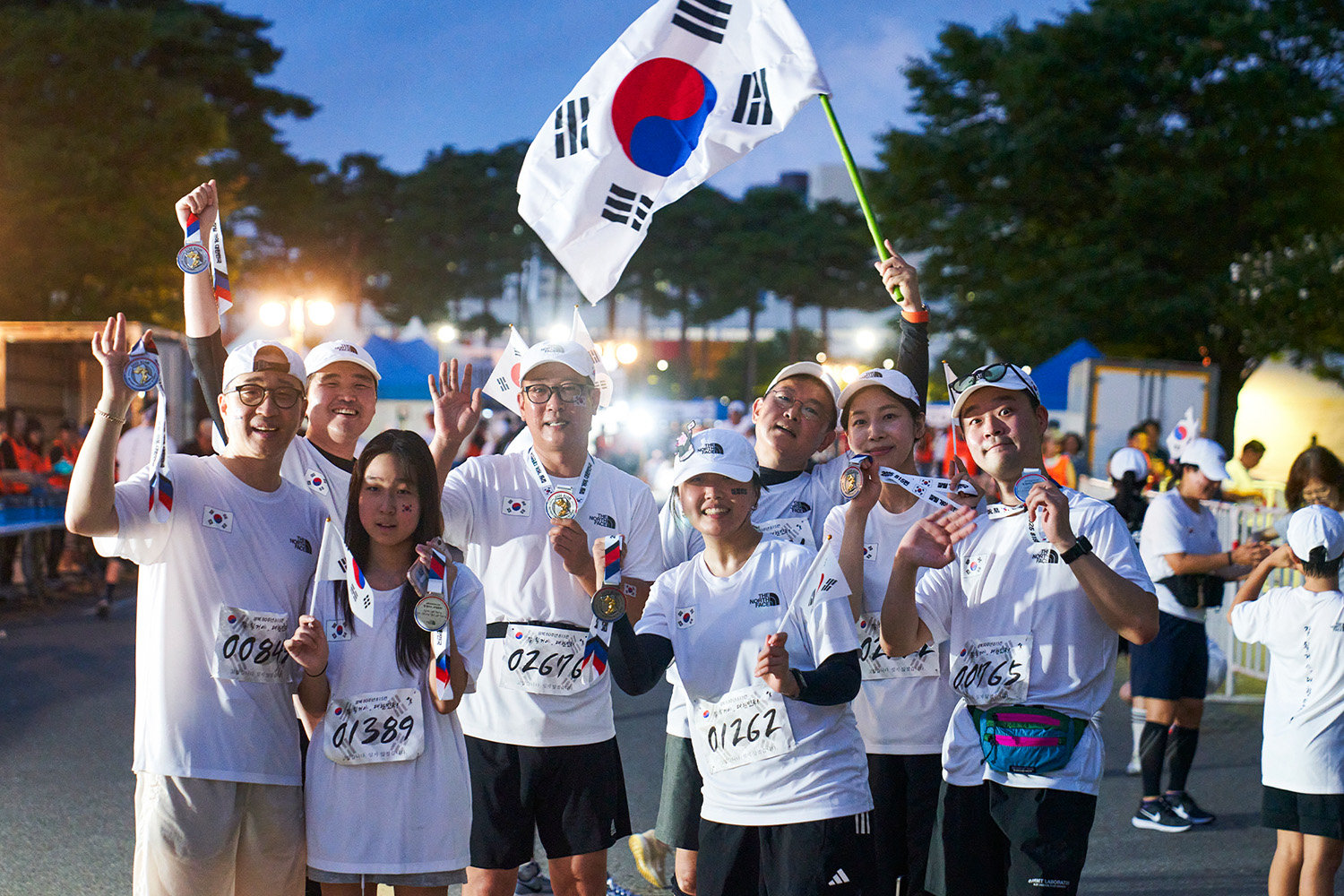 파라다이스그룹 참가자들이 태극기를 흔들며 완주를 축하하고 있다