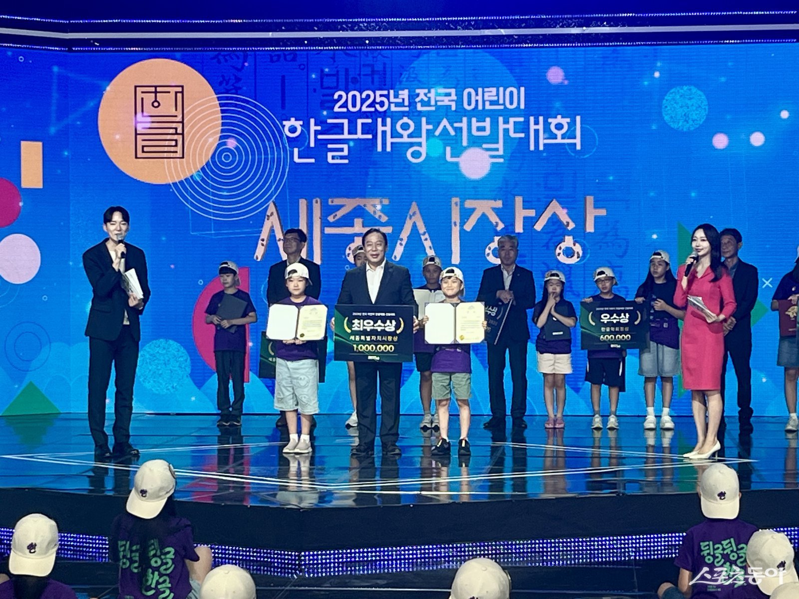 세종특별자치시(시장 최민호)는 지난 23일 대전 TJB방송국 공개홀에서 한글날을 기념해 ‘2025 전국 어린이 한글대왕 선발대회’를 개최했다(최민호(가운데)시장과 최우수상을 받은 송정우(왼쪽 두 번째), 곽하은(왼쪽 네 번째)). 사진제공|세종시