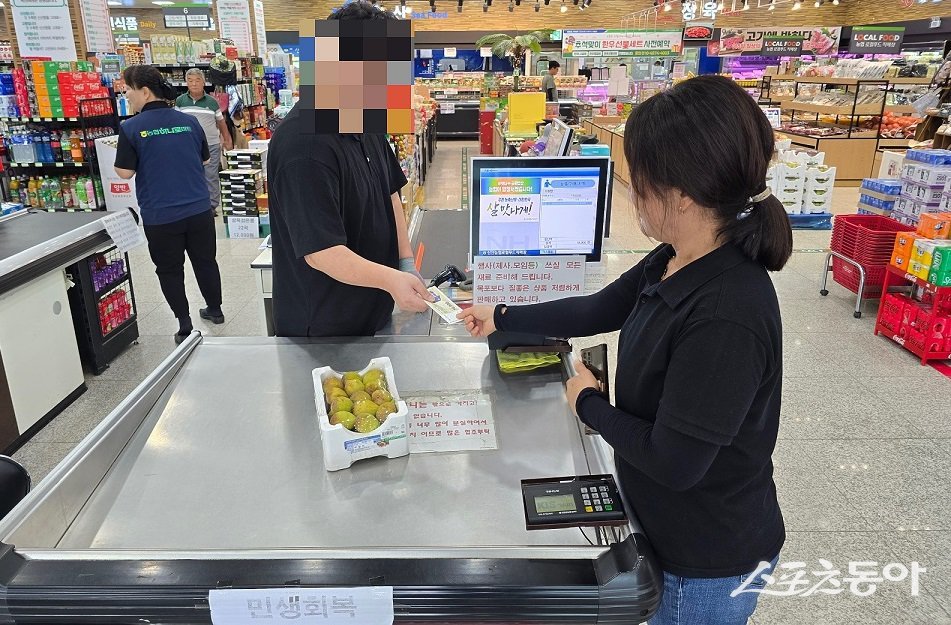 신안군 암태면 주민이 민생회복 소비쿠폰으로 지급된 지역사랑 상품권으로 하나로마트에서 과일을 구매하고 있는 모습. 사진제공=신안군