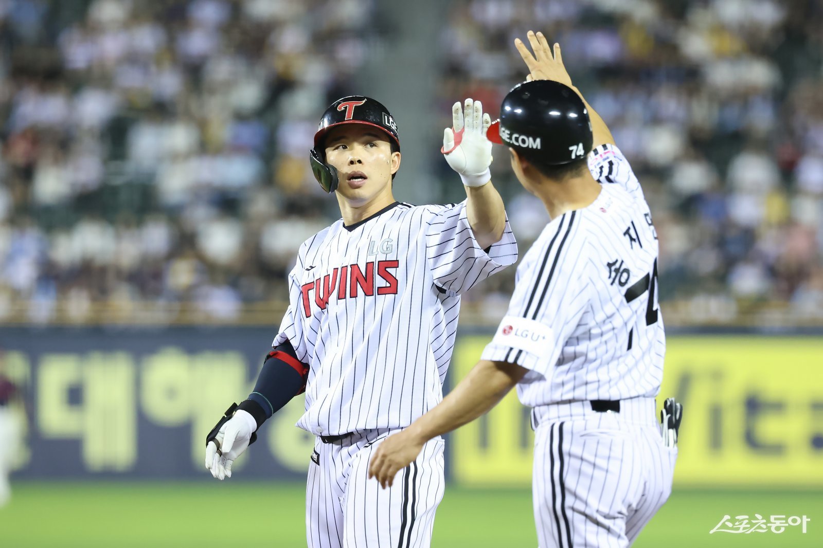 LG 문성주가 2일 잠실구장에서 열린 롯데와 홈경기 8회말 좌전안타로 출루한 뒤 송지만 주루코치와 손뼉을 마주치고 있다. 사진제공｜LG 트윈스