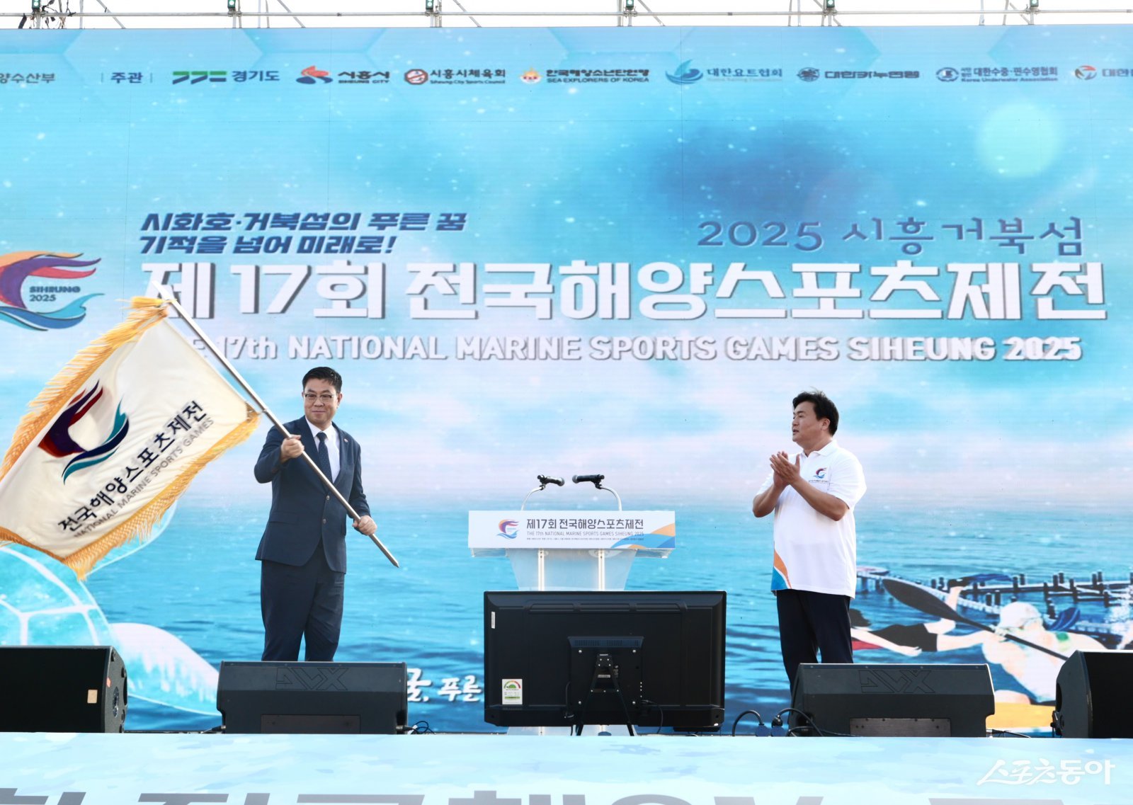 제18회 전국해양스포츠제전 개최지로 선정된 경남 거제시의 민기식 부시장(왼쪽)이 임병택 시장으로부터 대회기를 전달받았다. 사진제공｜시흥시