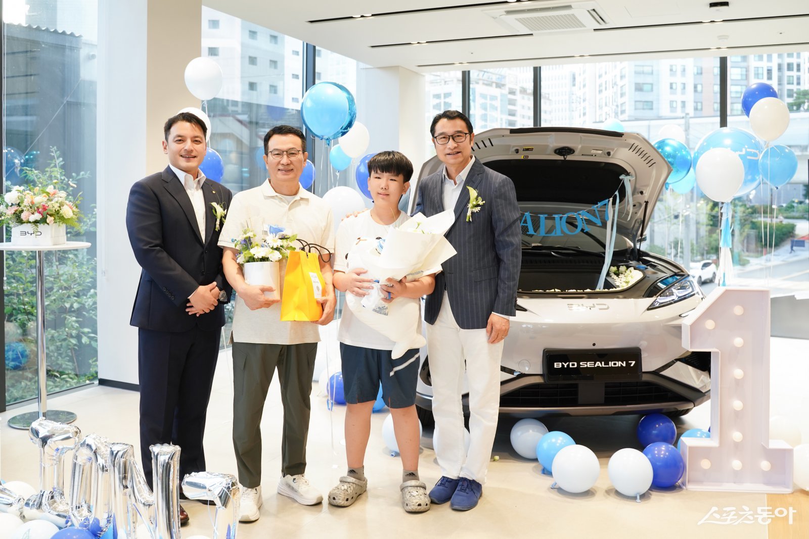  BYD코리아가 10일 부산 동래 전시장에서 씨라이언 7의 첫 출고식을 진행했다. DT네트웍스 권혁민 대표이사, 씨라이언 7 첫번째 고객 가족, BYD 아·태 자동차 영업사업부 류쉐량 총경리(왼쪽부터). 사진제공 ｜ BYD코리아