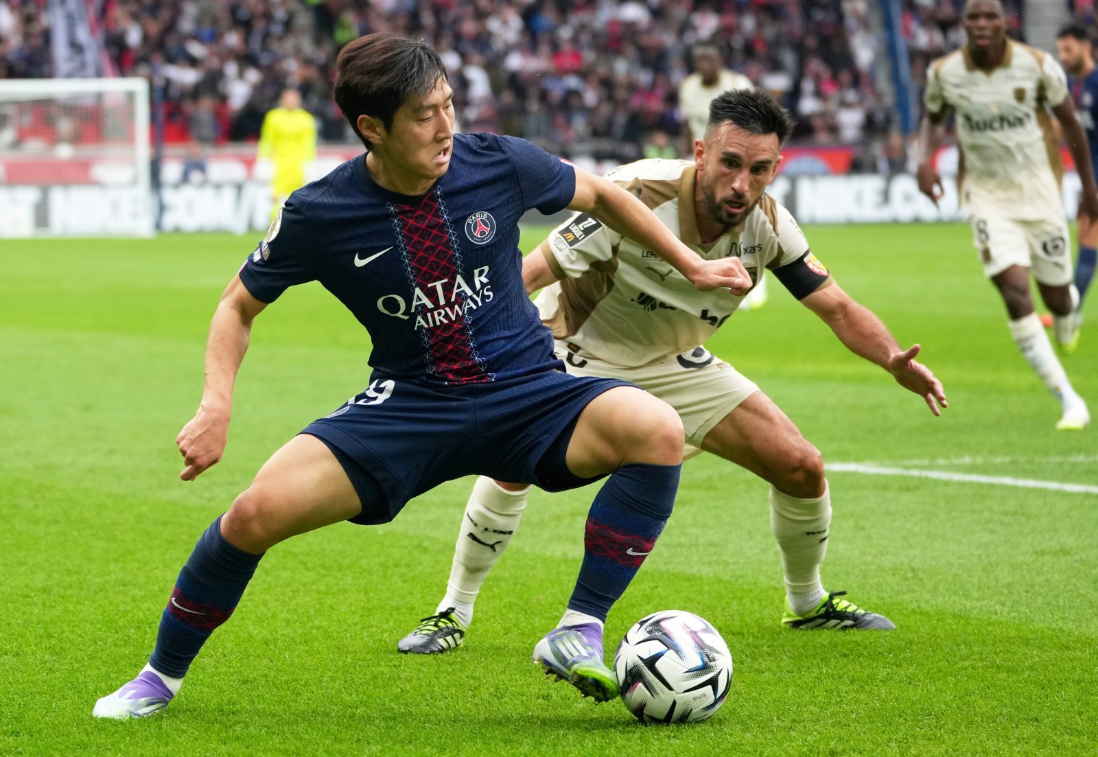 PSG 이강인(왼쪽)이 15일(한국시간) 홈에서 열린 랑스와 프랑스 리그앙 4라운드 홈경기에서 상대 선수와 볼을 다투고 있다. 이날 이강인은 오른 발목 통증으로 중도 교체됐다. 파리|AP뉴시스