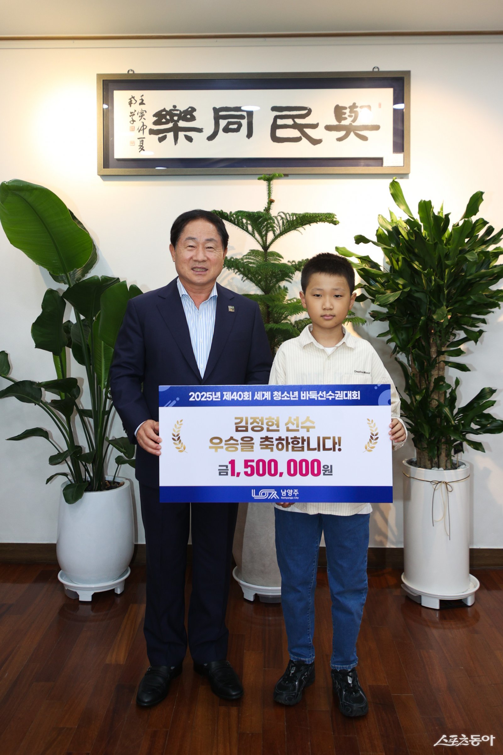 주광덕 시장(윈쪽)은 19일 시장 집무실에서 제40회 세계 청소년 바둑선수권대회 주니어부(U-12)에서 우승한 김정현 선수에게 포상금 150만 원을 전달하고 기념촬영하고있다. 사진제공ㅣ남양주시