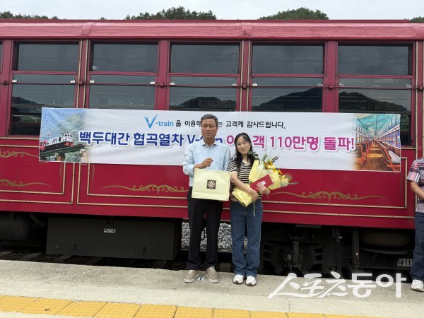 최창섭 봉화축제관광재단 대표이사가 백두대간 협곡열차 110만 명째 이용객에게 기념품을 전달하고 읶다. 사진제공 ㅣ 봉화군