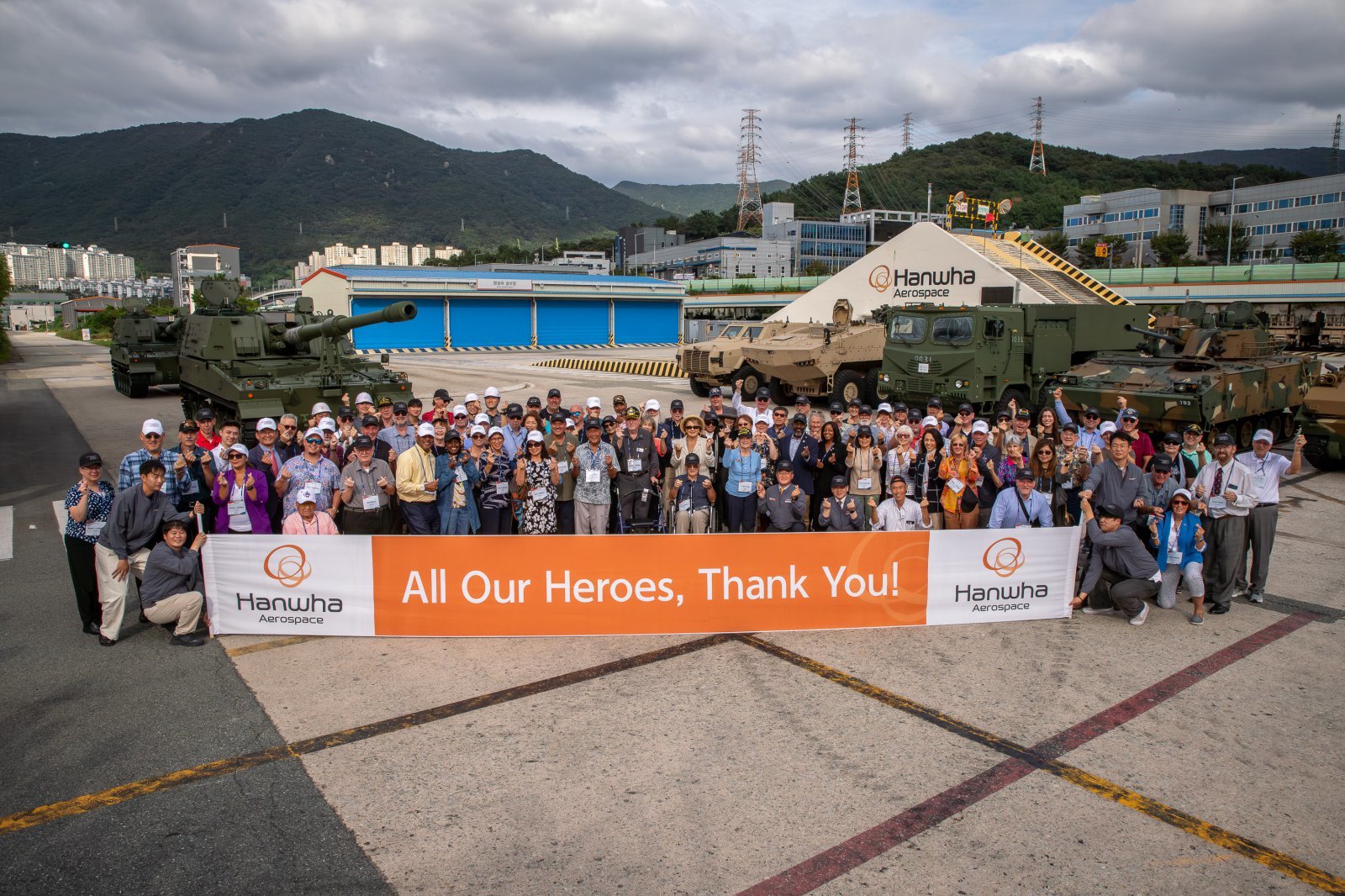 한화에어로스페이스 창원2사업장에서 진행된 ‘참전용사 재방한 행사’에서 6·25전쟁 미국 참전용사 85명 등 관계자들이 주요 무기체계 앞에서 기념촬영하고 있다. 사진제공 |한화에어로스페이스