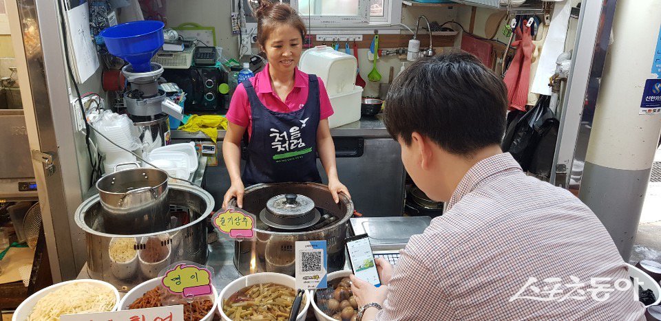 시흥 삼미시장에서 한 시민이 시루로 결제하고 있다. 사진제공|시흥시