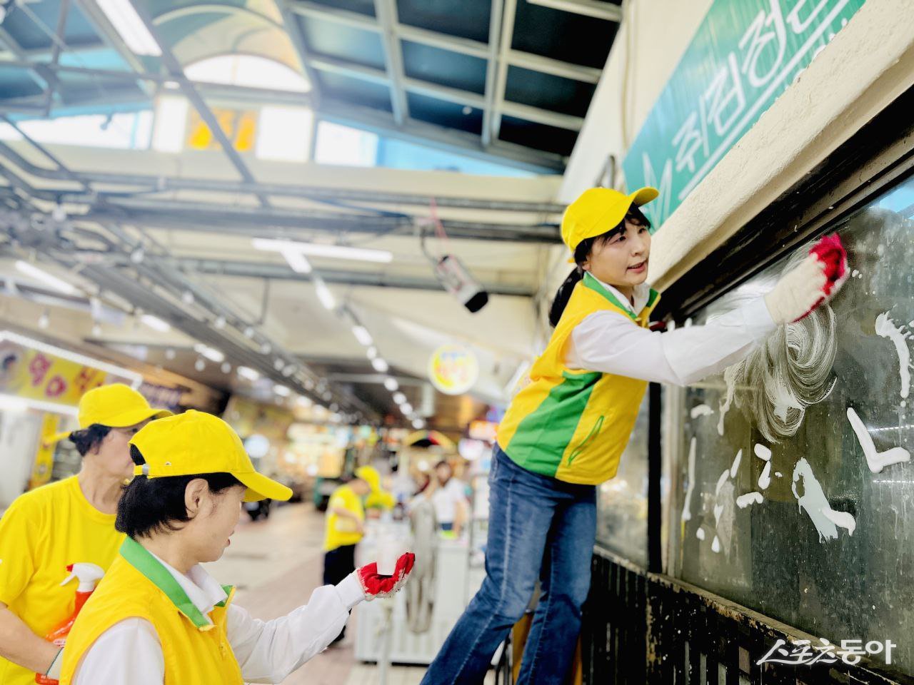 추석 연휴를 앞두고 재래시장을 찾은 마산지부 봉사자들이 시장 환경 정화를 위해 유리를 닦고 있다. (사진 제공=신천지자원봉사단 마산지부)