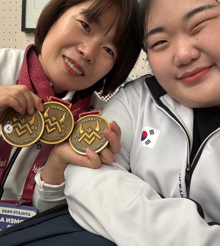 한국역도 간판 박혜정(오른쪽)이 11일(한국시간) 노르웨이 푀르데에서 열린 2025세계선수권 마지막 날 여자 86㎏ 이상급 경기에서 인상 125㎏, 용상 158㎏, 합계 283㎏를 들어 3개 부문 모두 금메달을 따낸 뒤 박종화 대표팀 코치와 기뻐하고 있다. 그는 경기를 앞두고 허리와 무릎통증이 재발했지만 이를 이겨내고 시상대 가장 높은 곳에 섰다. 사진출처│박혜정 인스타그램