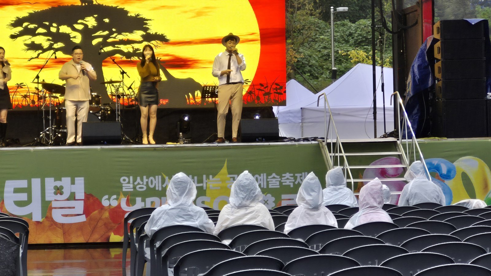 공연 중 갑자기 쏟아진 비에도 꿋꿋하게 자리를 지키고 있는 ‘낭만합격’ 관람객들의 모습. 파주 | 양형모 기자