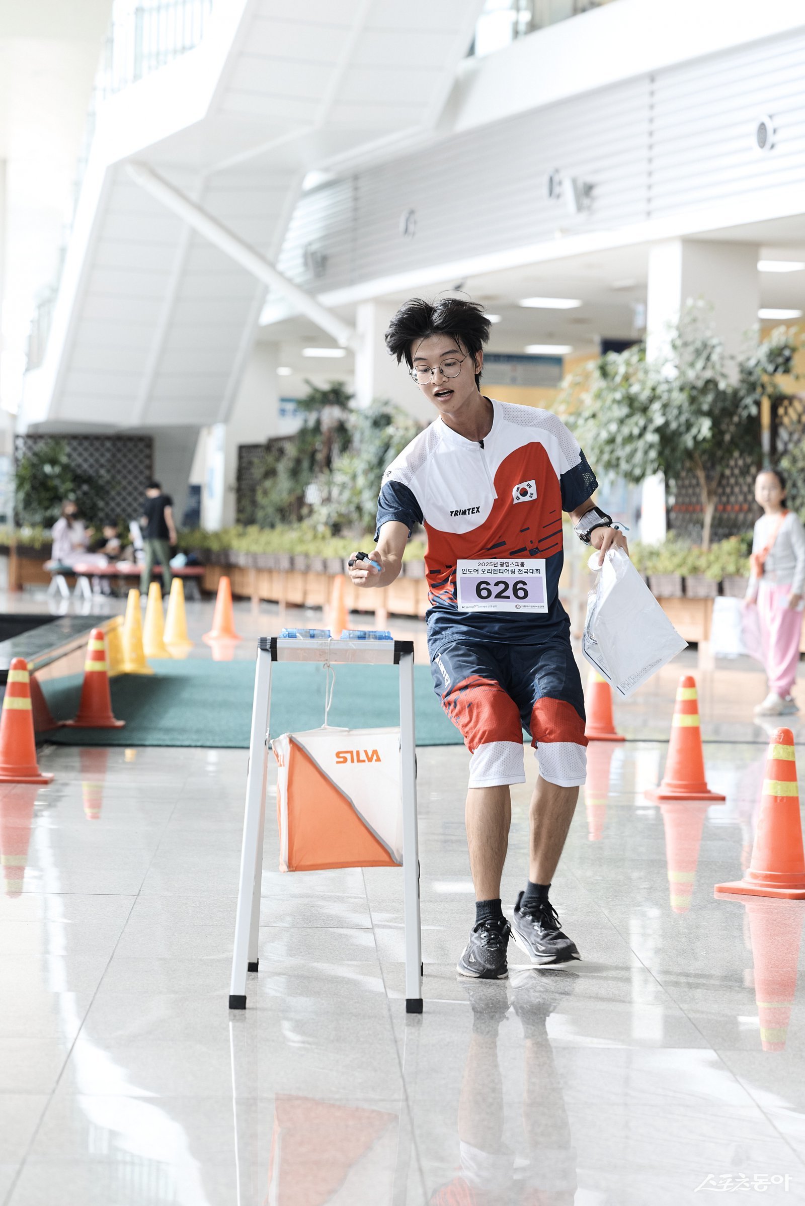 오리엔티어링 청소년 국가대표 하헌빈씨가 도착 지점에서 전자카드를 찍고 있는 모습 .