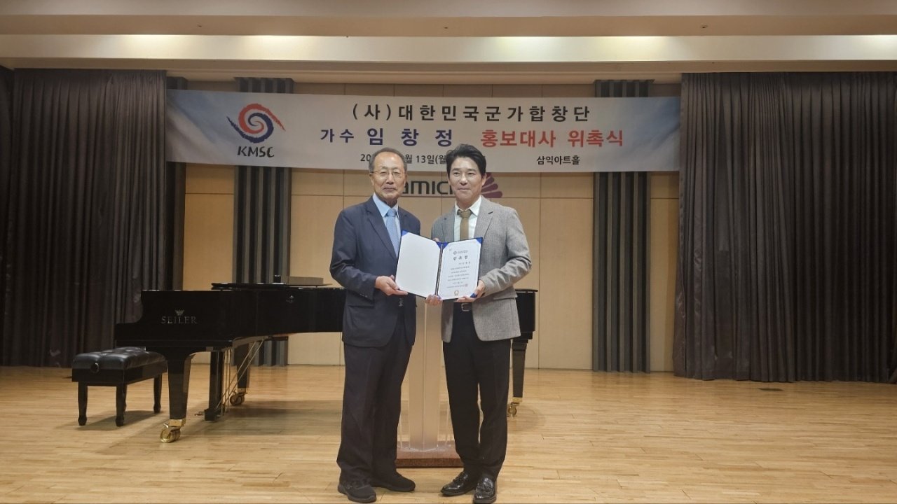 홍두승 군가합창단 단장(왼쪽)으로부터 홍보대사 위촉장을 받고있는 가수 임창정. 사진제공ㅣ대한민국군가합창단