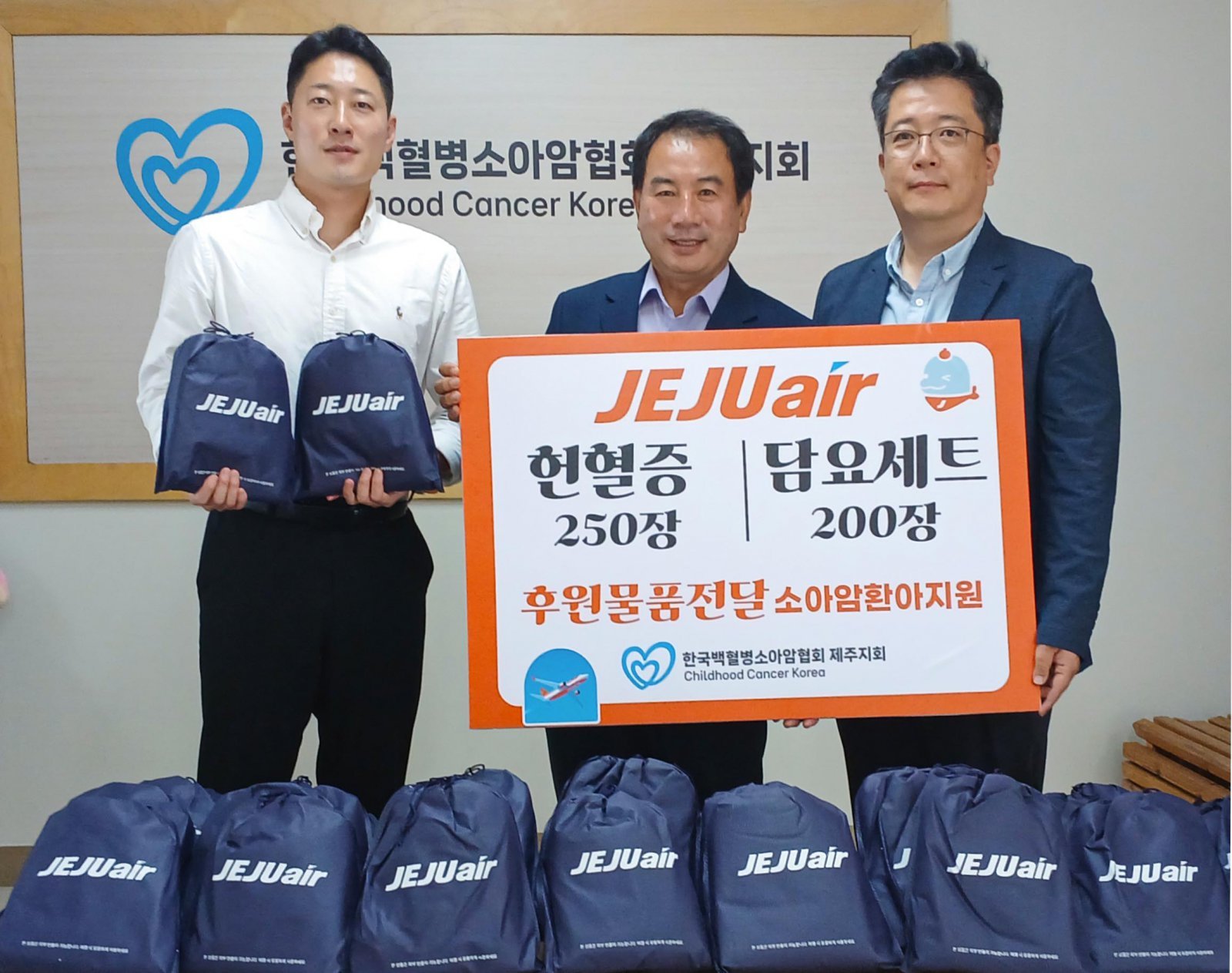 제주항공 김정제 산업안전보건팀장(오른쪽)이 15일 한국백혈병소아암협회 고경남 제주지회장(가운데)에게 물품을 전달한 뒤 기념촬영을 하고 있는 모습. 사진제공｜제주항공