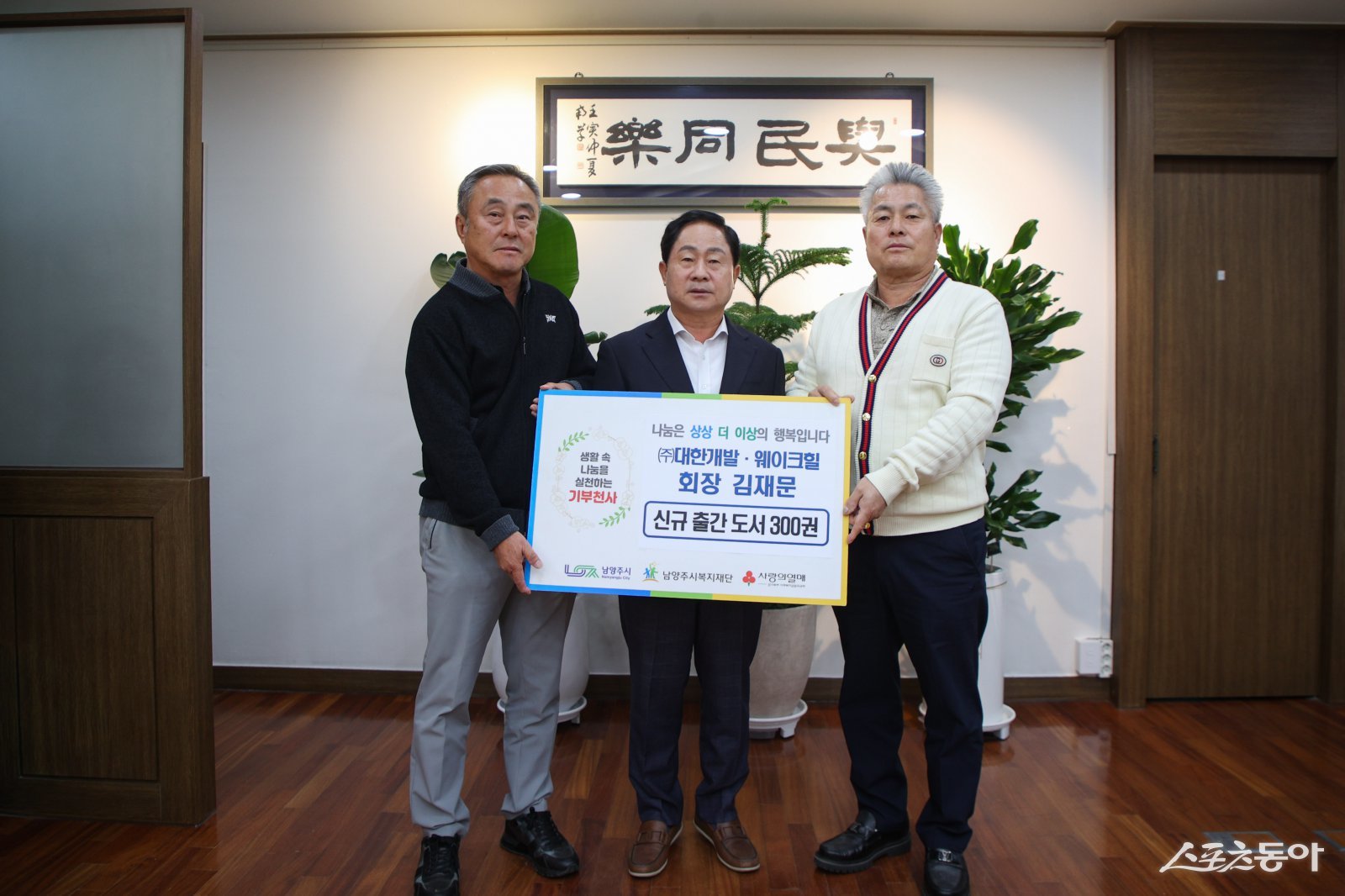 주광덕 시장(가운데)은 22일 시장 집무실에서 김재문 ㈜대한개발 회장으로 부터 신간 도서 ‘그 아이는 바보 부자’ 300권을 기증받고 기념 촬영하고 있다. 사진제공ㅣ남양주시 