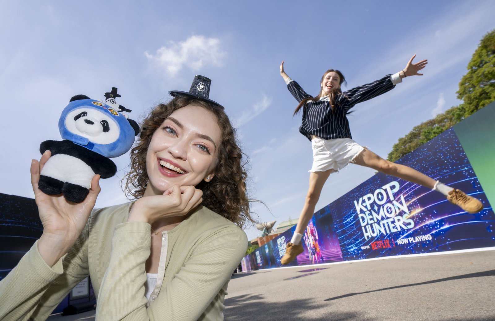 판다 더피 인형을 들고 기념사진을 찍고 있는 관광객