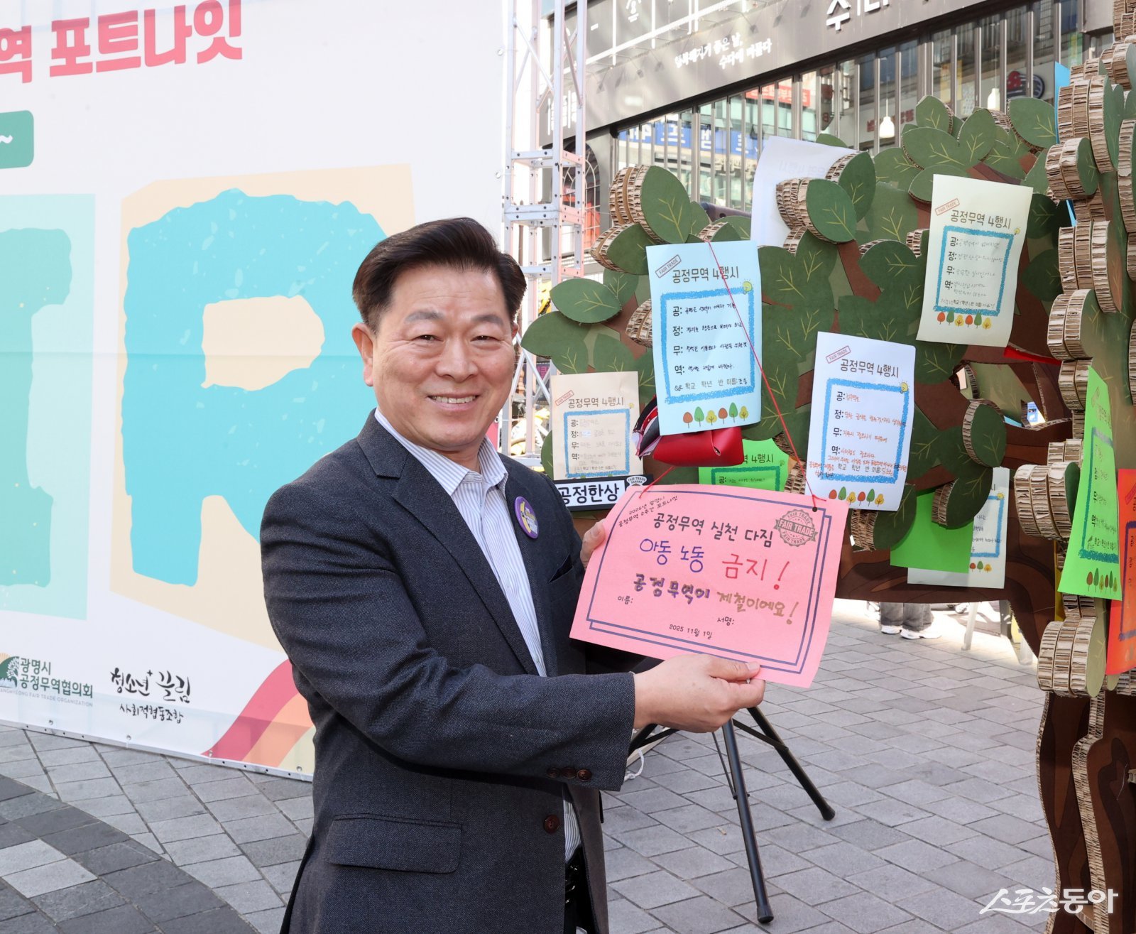 박승원 광명시장이 지난 1일 철산상업지구 원형광장에서 열린 ‘2025 공정무역 2주간 캠페인-포트나잇’의 당일 캠페인에 참석해 공정무역 소비 실천을 다짐하는 서약문을 들고 기념사진을 촬영하고 있다.사진제공|광명시