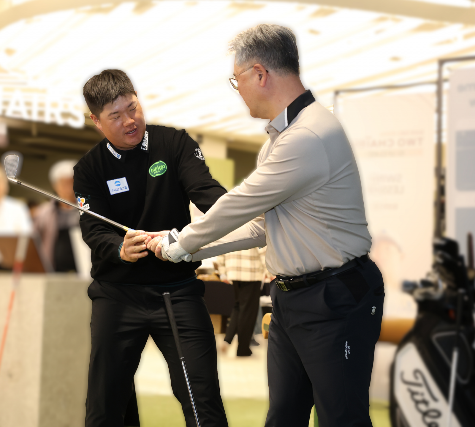 우리투자증권 고객에게 레슨을 하고 있는 임성재(왼쪽). 사진제공|우리금융