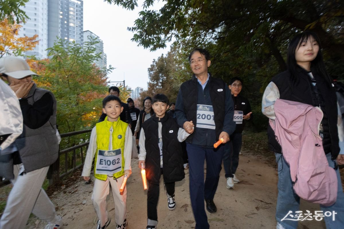 이동환 고양특례시장이 8일 일산호수공원에서 열린 ‘2025 고양 호롱불 나이트워크에서 초등학생 손을 잡고 걷고있다. 사진제공ㅣ고양시