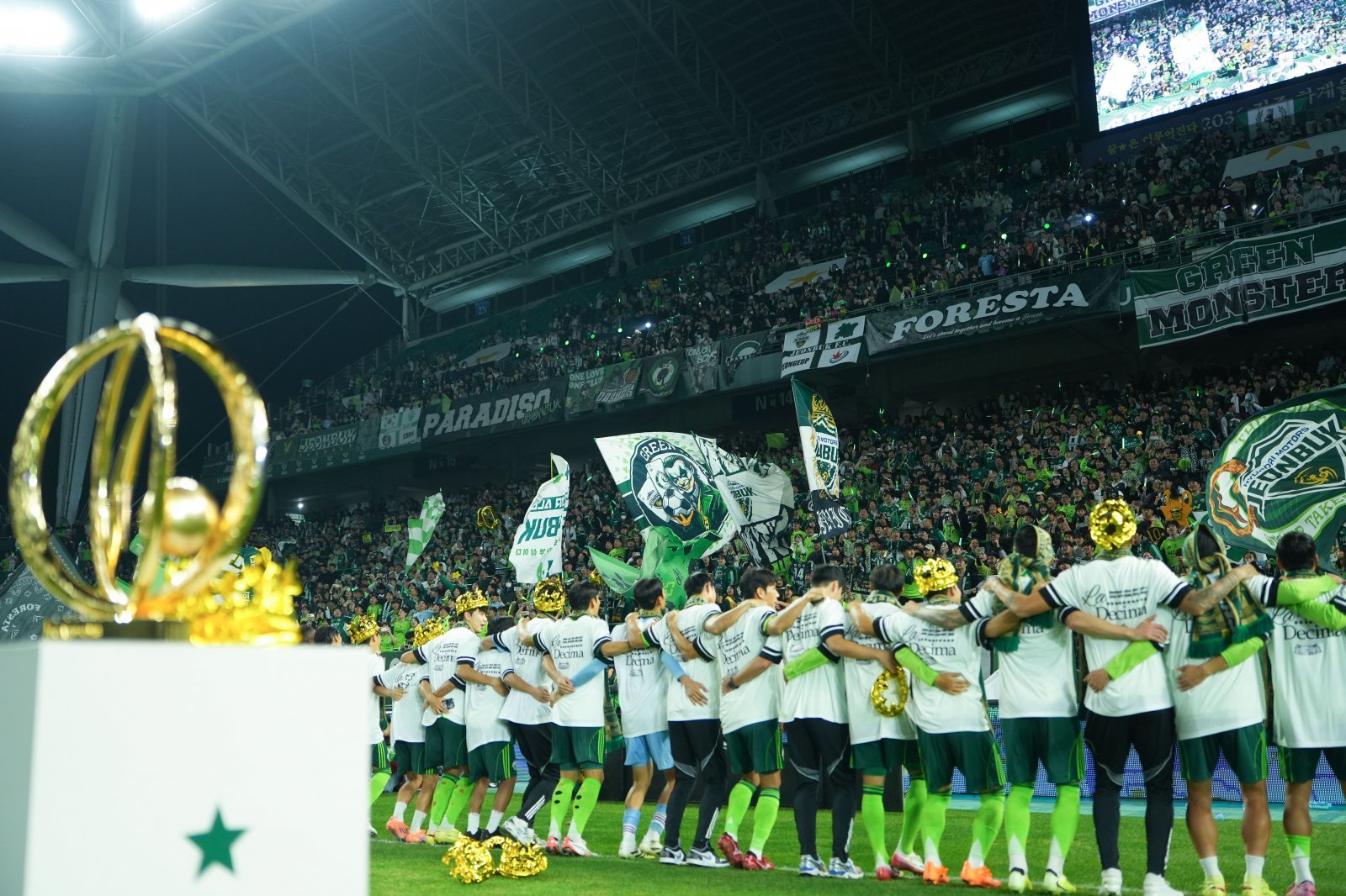 전북 선수들이 8일 전주성에서 진행된 우승 행사 도중 트로피를 배경으로 홈팬들과 함께 특유의 ‘오오렐레’ 세리머니를 하며 열기를 고조시키고 있다. 사진제공|전북 현대