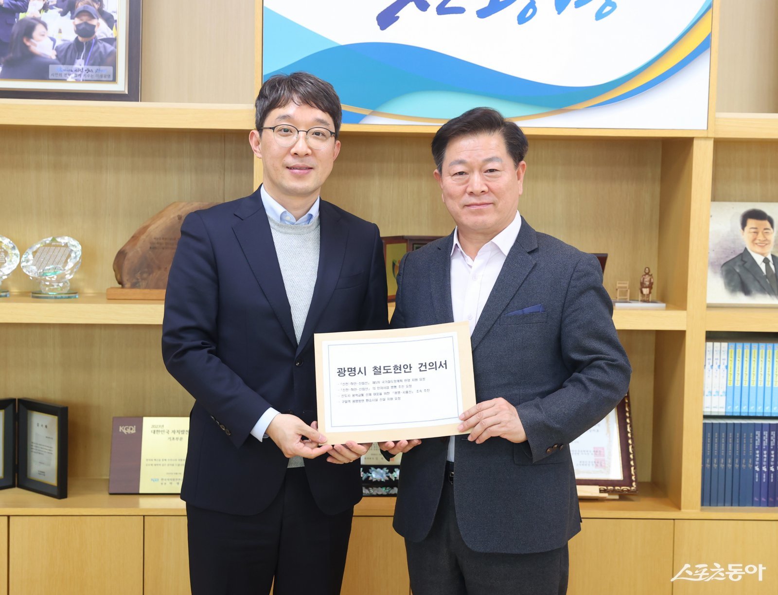 박승원 광명시장(오른쪽)이 지난 11일 오후 시장 집무실에서 김기범 경기도 철도항만물류국장(사진 왼쪽)에게 신천~하안~신림선 등 철도 사업의 조속한 추진을 위한 경기도의 적극적인 협조와 지원을 요청하는 건의문을 전달하고 있다. 사진제공|광명시