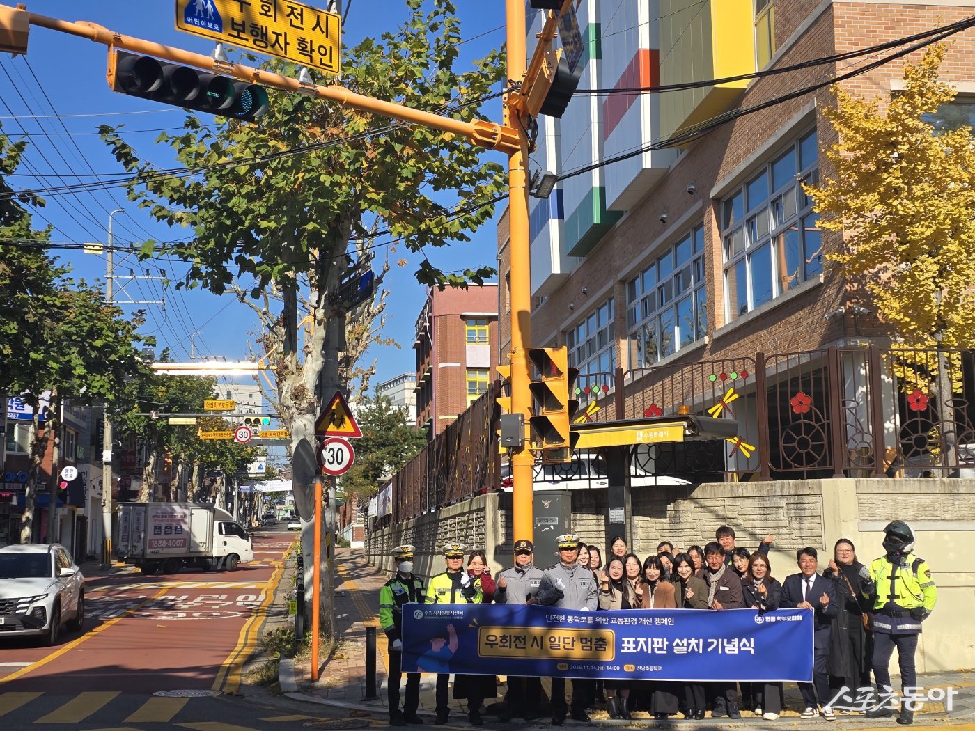 지난 14일 수원시 영통구 매탄 2동 산남초등학교 앞 사거리에서 안전한 통학로 개선을 위한 ‘우회전 시 보행자 확인’ 표지판 설치 기념식이 열렸다. 사진제공｜수원시자원봉사센터