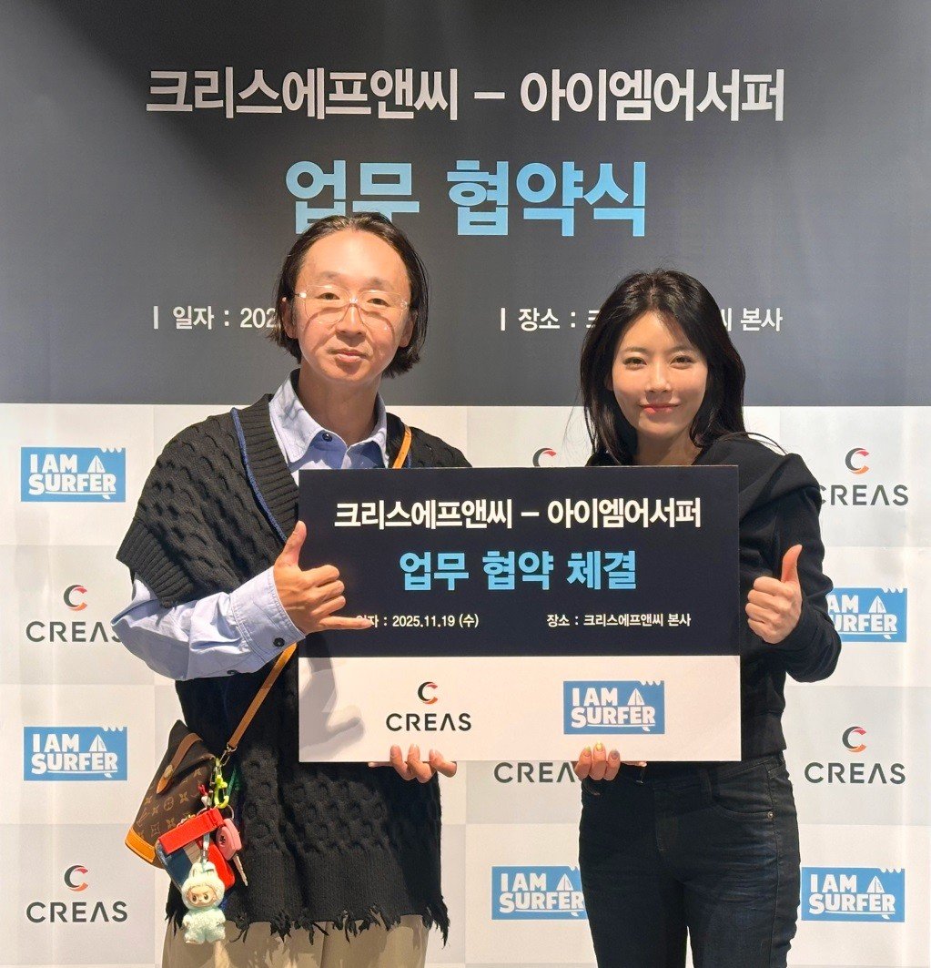 크리스에프앤씨 우윤주 이사(왼쪽)가 아이엠어서퍼 전성곤(곤대장) 대표와 업무협약을 체결한 뒤 포즈를 취하고 있다.