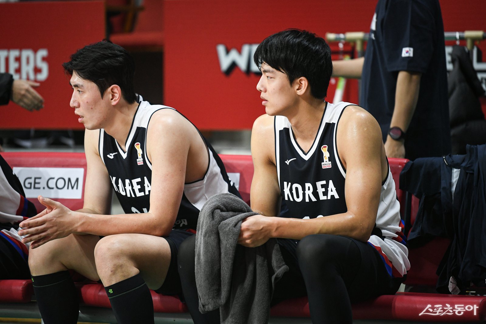 남자농구대표팀 강상재(왼쪽)와 김보배가 25일 안양정관장아레나에서 열린 연습경기 도중 벤치에서 경기를 지켜복보 있다. 사진제공|점프볼