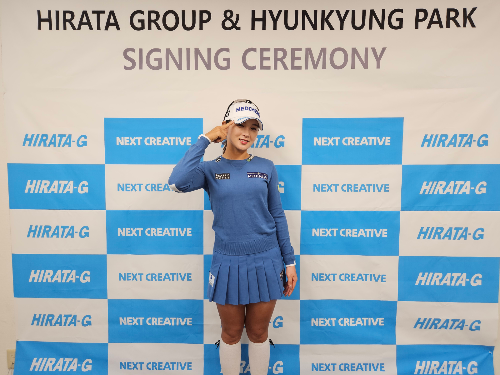 박현경이 모자 챙 우측에 있는 히라타그룹의 로고를 가리키고 있다.
