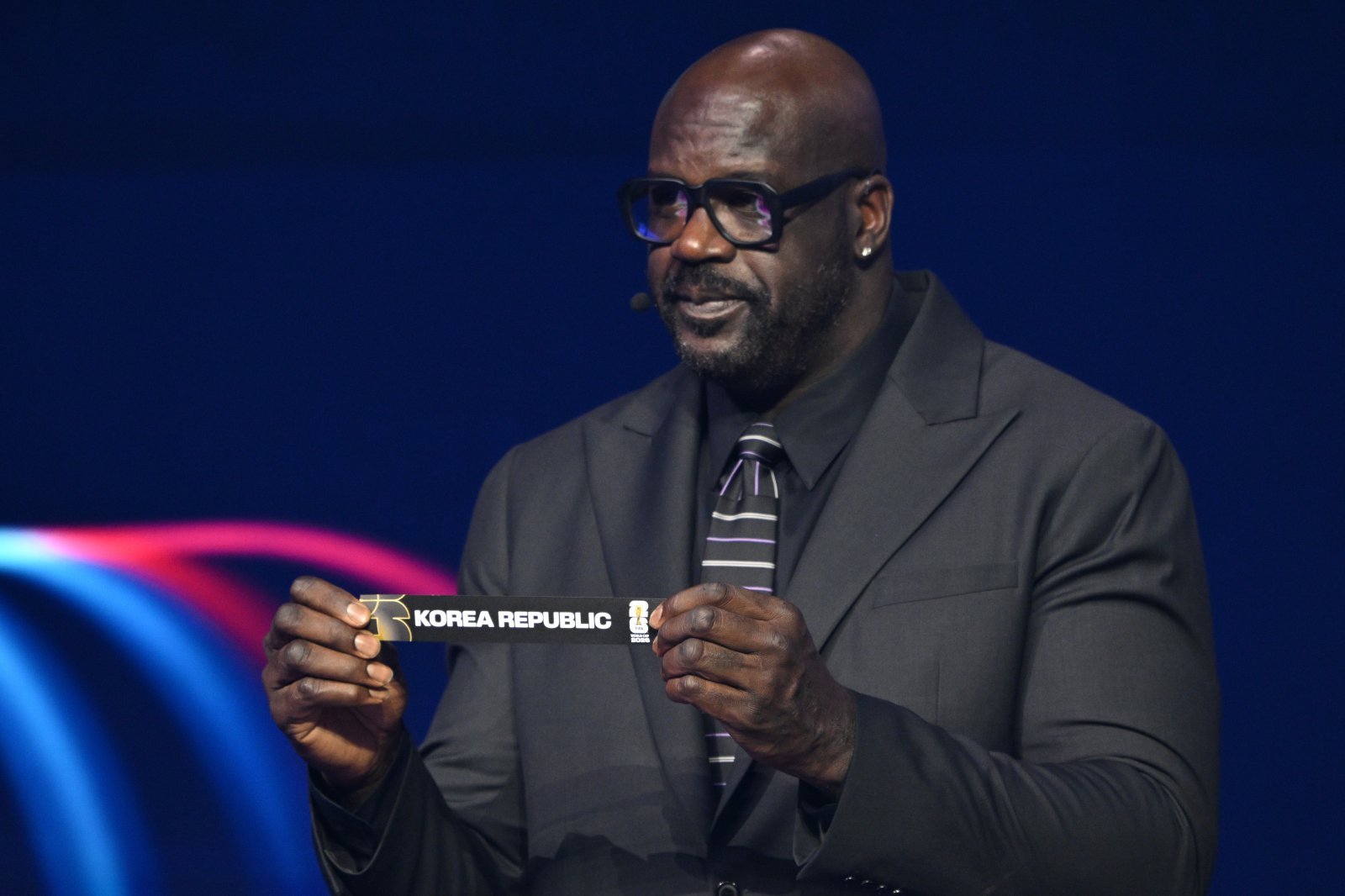 전 NBA 스타 샤킬 오닐이 6일(한국시간) 미국 워싱턴DC 케네디센터에서 진행된 2026북중미월드컵 조추첨식 도중 포트2의 ‘한국’을 들어보이고 있다. 워싱턴｜AP뉴시스