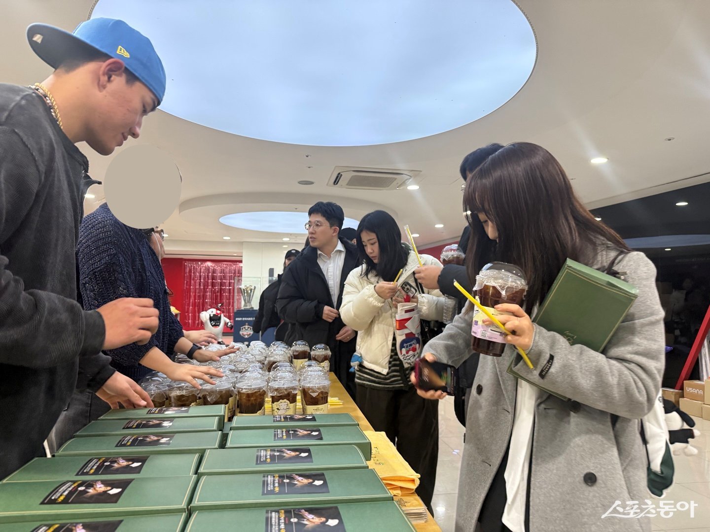 KT 안현민(왼쪽)이 6일 수원KT위즈파크 구내식당에 팬 46명을 초청해 직접 만든 요리를 제공한 뒤, 사비로 구매한 음료와 위즈TV가 준비한 기념 수건을 직접 나눠주고 있다. 사진제공|KT 위즈