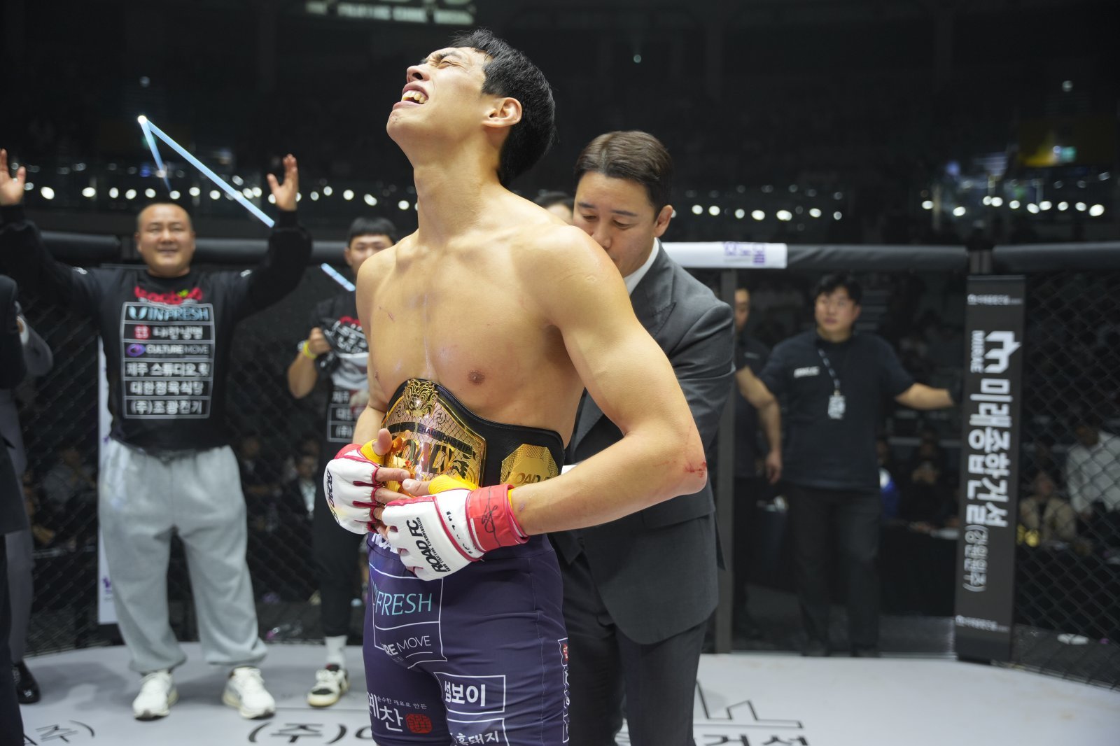 윤태영(앞)이 7일 장충체육관에서 열린 ‘굽네 로드FC 075’에서 로드FC 웰터급 초대 챔피언에 오른 뒤 정문홍 로드FC 회장으로부터 벨트를 받고 있다. 사진제공｜로드FC