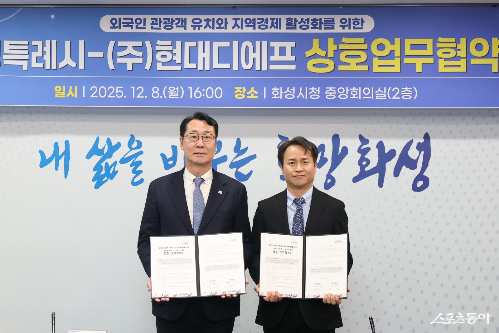 정명근 화성특례시장(사진 왼쪽)과 박장서 ㈜현대디에프 대표이사가 협약서를 들고 기념촬영하고 있다. 사진제공｜화성시