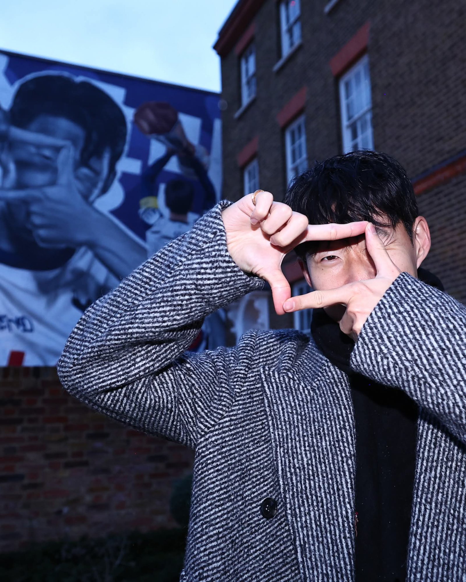 토트넘 팬들과 진짜 이별을 위해 런던을 방문한 손흥민이 10일(한국시간) 홈구장이 위치한 북런던 하이로드의 한 카페 외벽에 장식된 자신의 벽화 앞에서 ‘찰칵 세리머니’ 포즈를 취하고 있다. 사진출처|토트넘 홋스퍼 페이스북