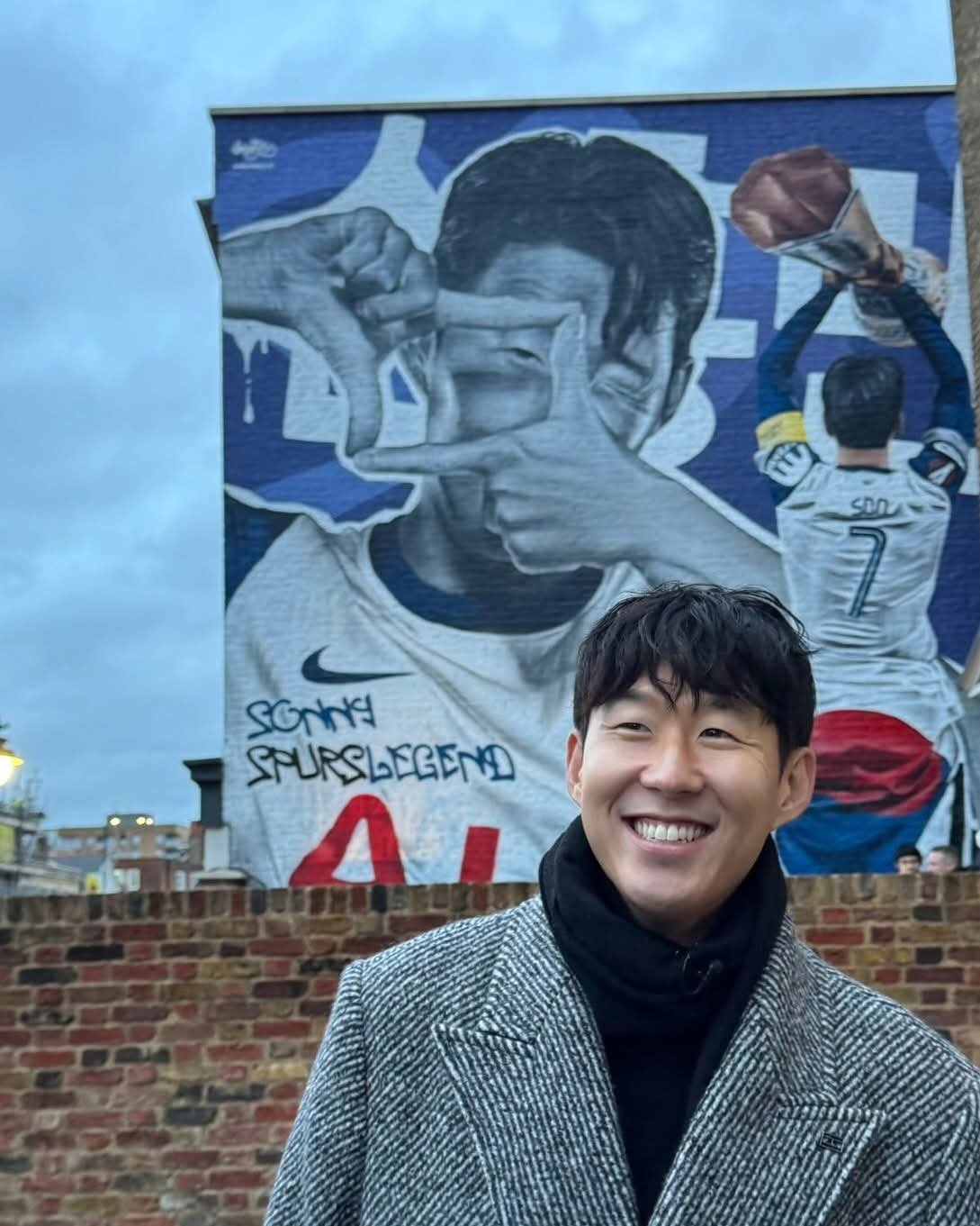 토트넘 팬들과 진짜 이별을 위해 런던을 방문한 손흥민이 10일(한국시간) 홈구장이 위치한 북런던 하이로드의 한 카페 외벽에 장식된 자신의 벽화 앞에서 활짝 웃고 있다. 사진출처|토트넘 홋스퍼 페이스북