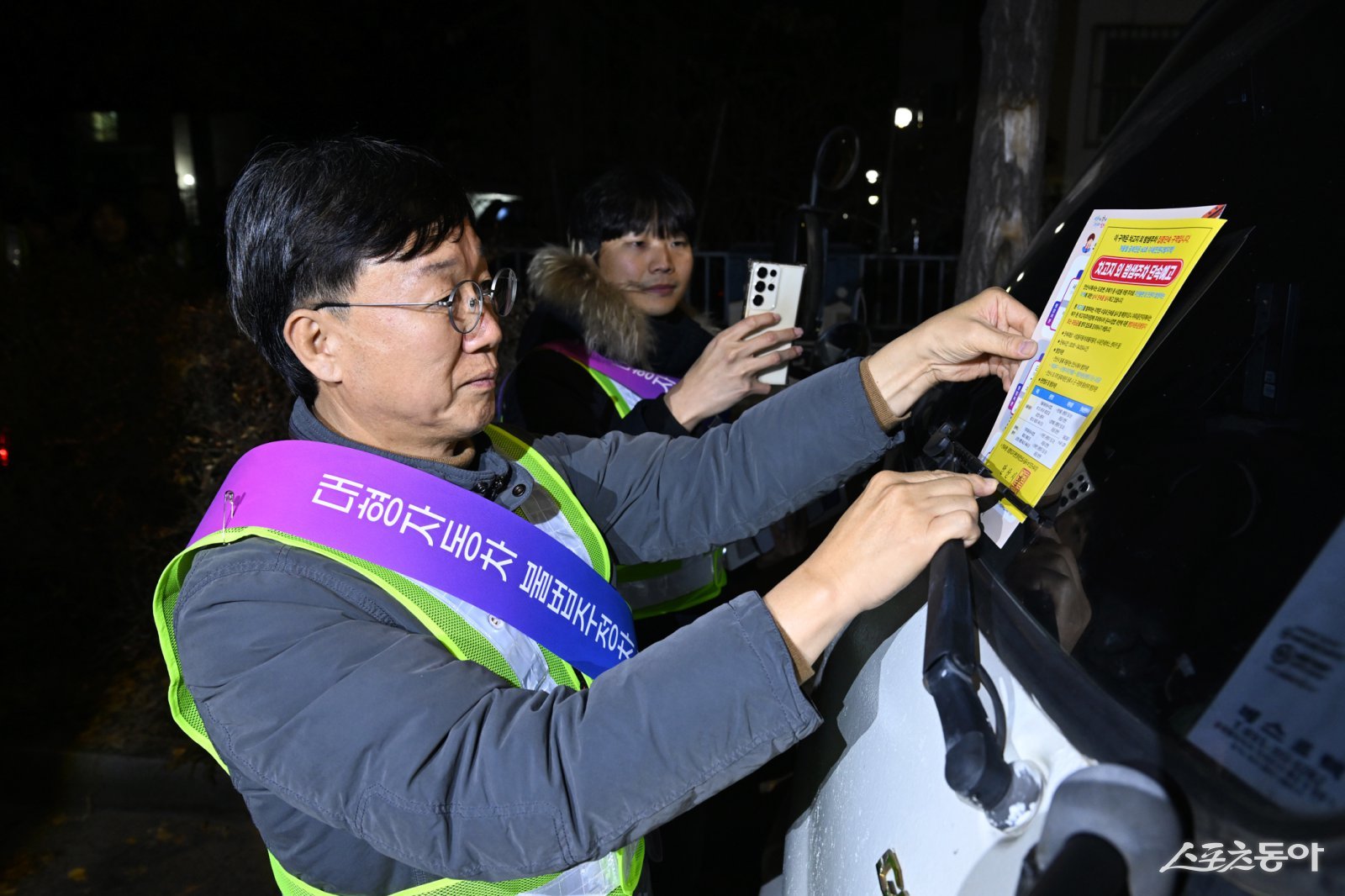 이민근 안산시장이 지난 20일 새벽시간, 단원구 와동 일대에 불법 밤샘주차된 대형차랑에 계도문을 부착하고 있다. 사진제공｜안산시