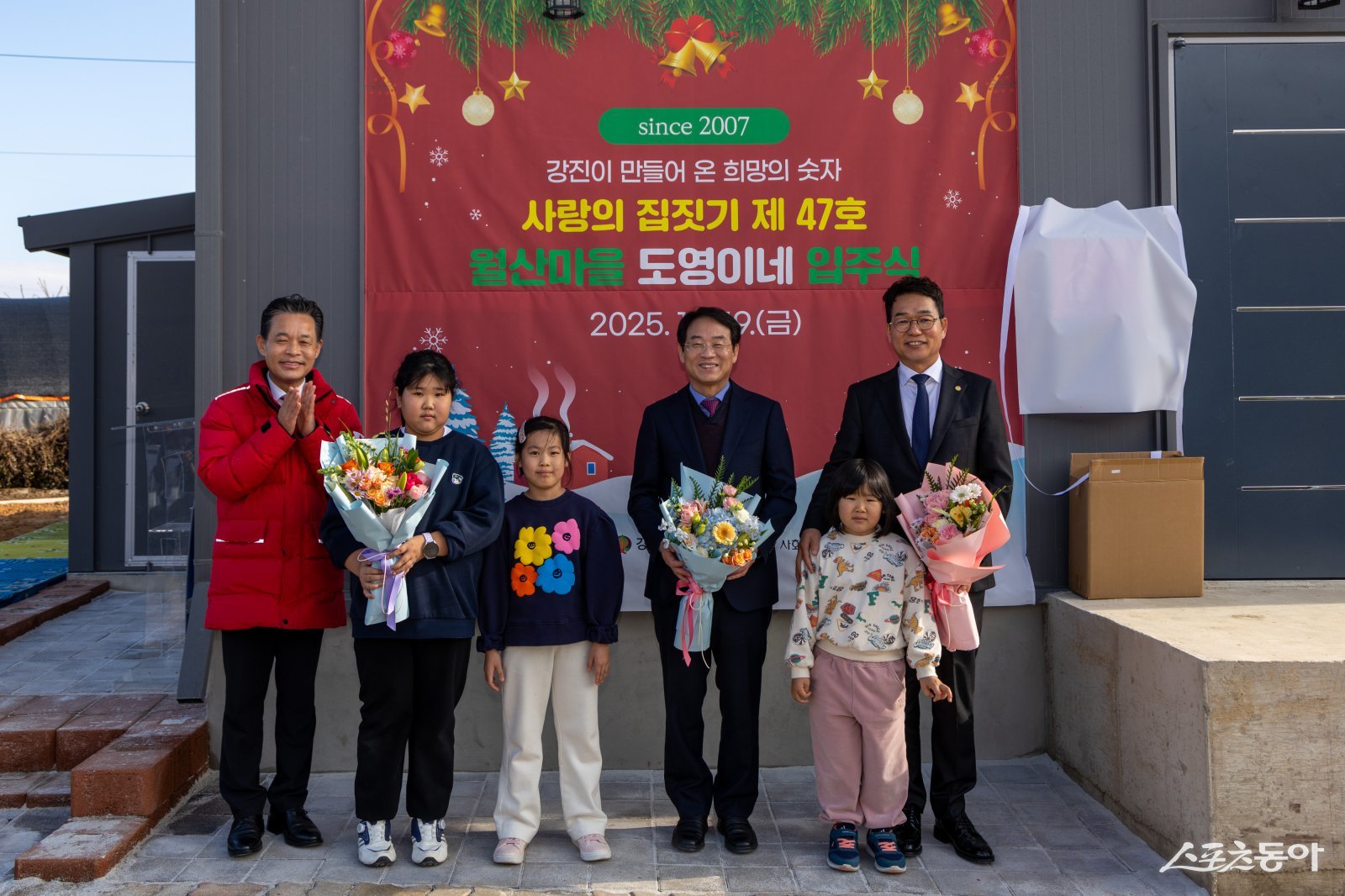 강진군이 성남에서 강진으로 귀촌한 8인 대가족에게  ‘제47호 사랑의 집짓기’ 입주식을 개최하고 기념촬영을 하고 있다. 사진제공=강진군