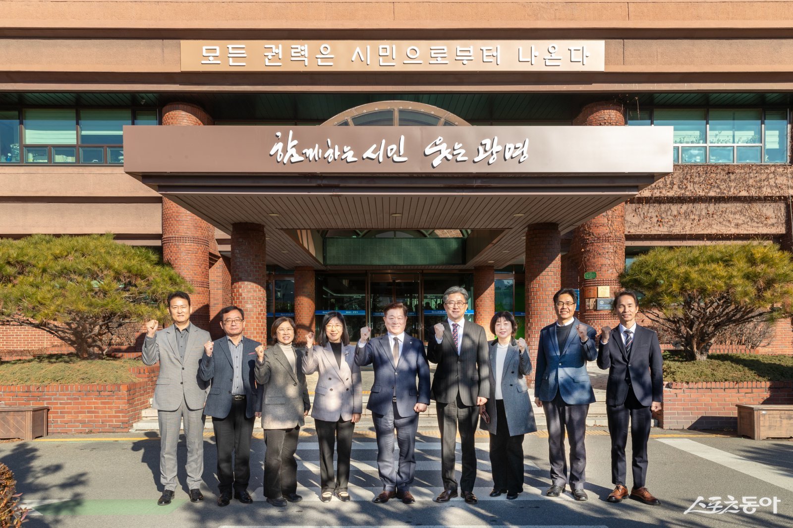 박승원 광명시장(사진 가운데)이 정순욱 부시장(사진 오른쪽 네 번째), 실국장들과 ‘모든 권력은 시민으로부터 나온다’는 문구가 새겨진 시청 본관 앞에서 기념사진을 촬영하고 있다. 사진제공｜광명시