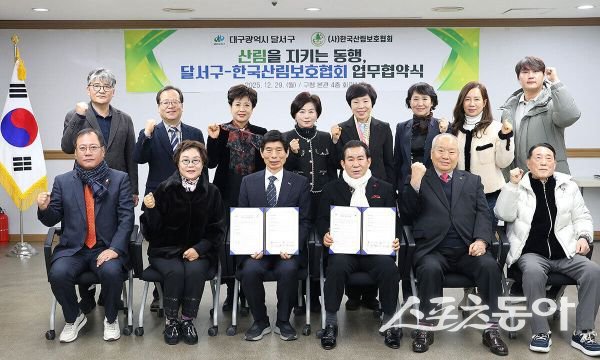 이태훈(앞줄 가운데 왼쪽) 구청장과 허태조 한국산림보호협회 중앙회장이 협약서를 들고 기념 촬영을 하고 있는 모습. 사진제공ㅣ대구 달서구