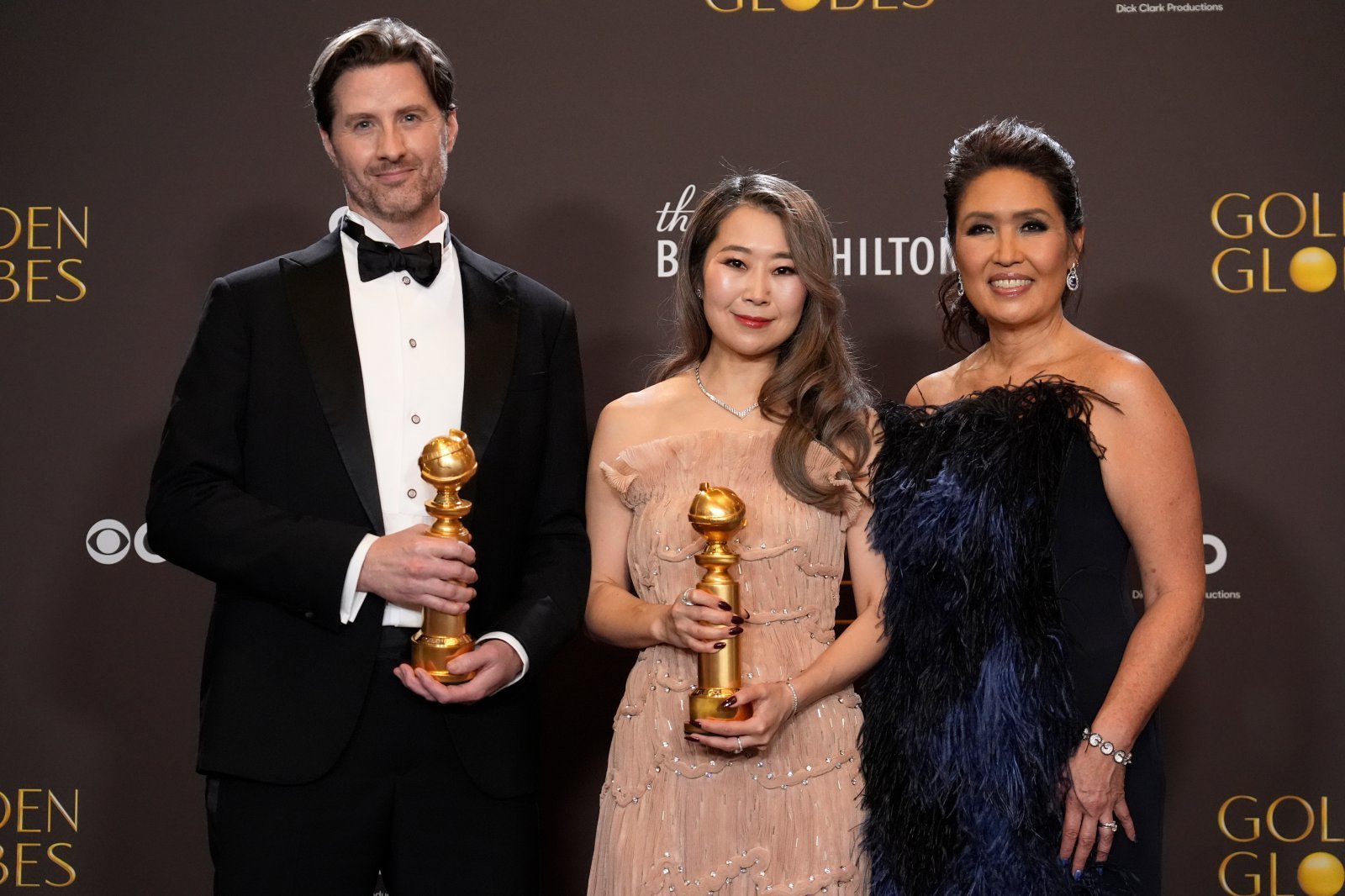 Chris Appelhans, from left, Maggie Kang, and Michelle Wong pose in the press room with the award for best motion picture ? animated for “Kpop Demon Hunters” during the 83rd Golden Globes on Sunday, Jan. 11, 2026, at the Beverly Hilton in Beverly Hills, Calif. (AP Photo/Chris Pizzello)