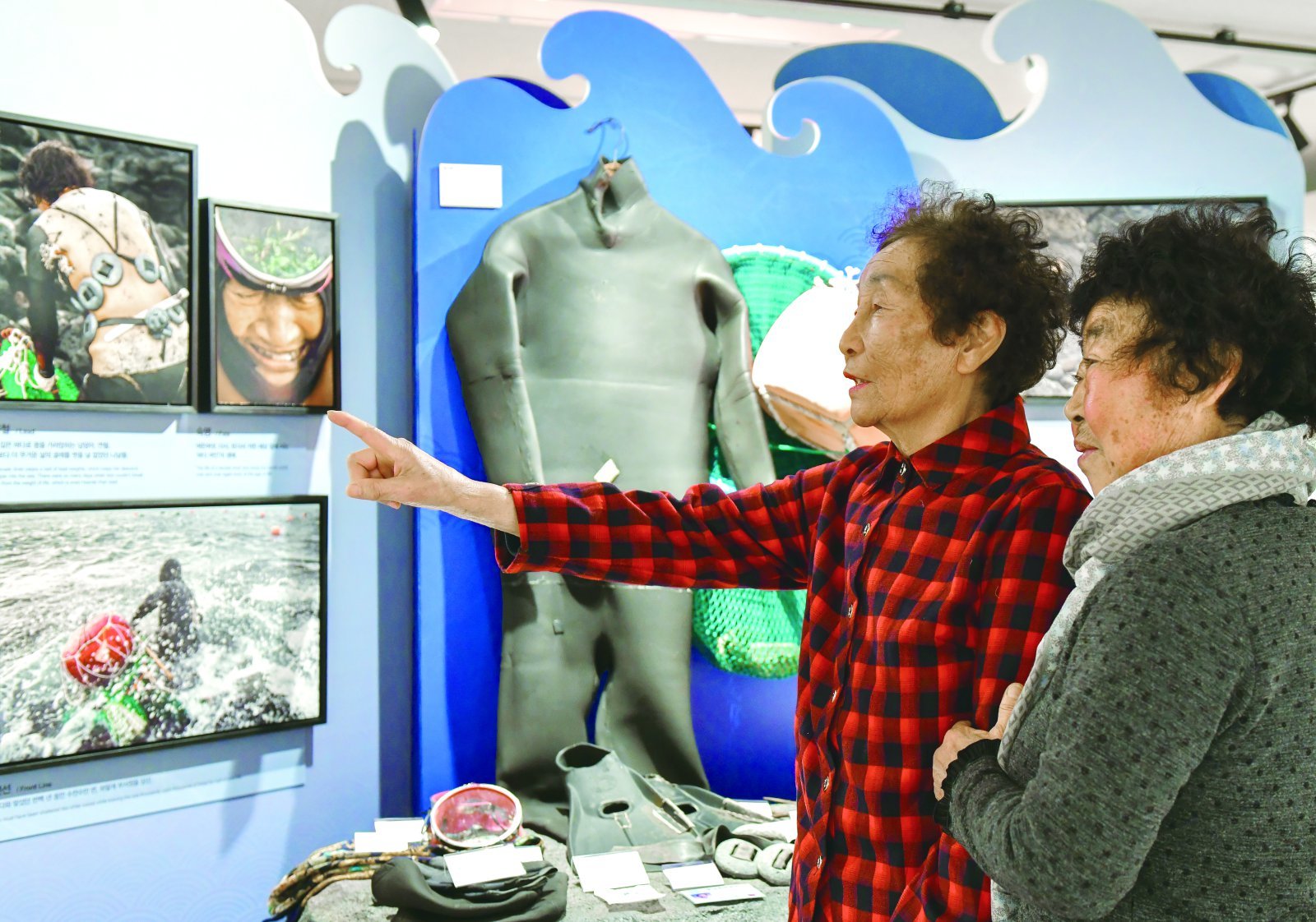 제주도 해녀들이 어머니전 제주도 스페셜존 작품들을 유심히 살피고 있다.