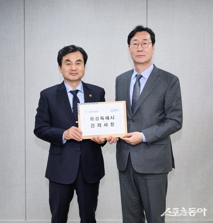 정명근 화성특례시장과 안규백 국방부장관이 건의문을 들고 사진촬영하고 있다. 사진제공|화성시