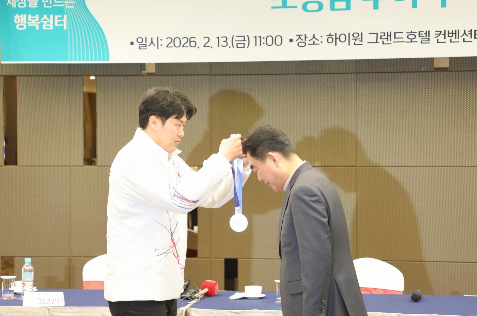 올림픽 은메달리스트 김상겸선수가 획득한 은메달을 최철규 강원랜드 대표이사 직무대행에게 걸어주고 있다