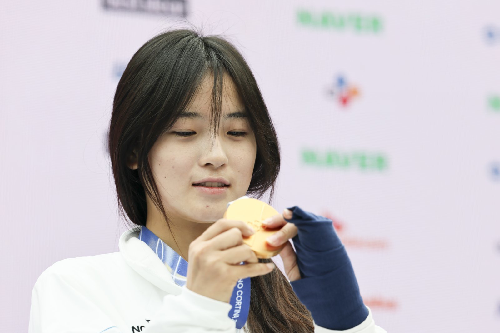 최가온이 14일(한국시간) 밀라노 코리아하우스에서 열린 기자회견 도중 금메달을 만져보고 있다. 밀라노ㅣ뉴시스