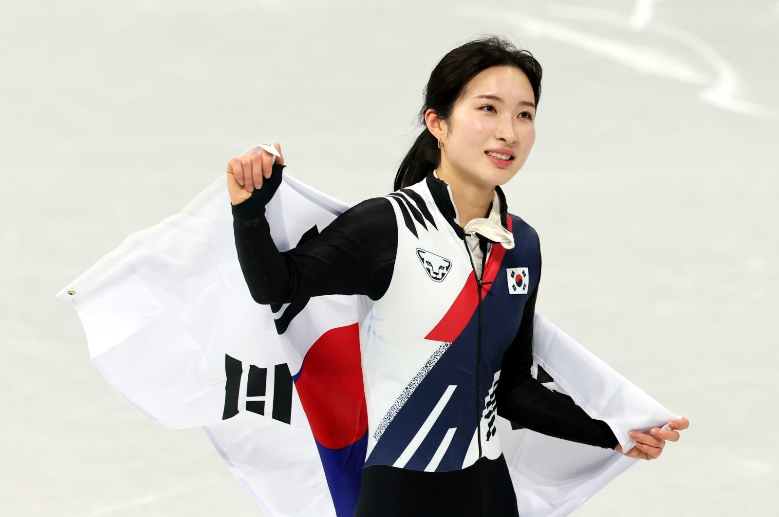 김길리가 16일(한국시간) 밀라노 아이스스케이팅 아레나에서 열린 쇼트트랙 여자 1000m 결선에서 1분28초614로 동메달을 따낸 뒤 태극기를 두르고 트랙을 돌고 있다. 밀라노ㅣ뉴시스