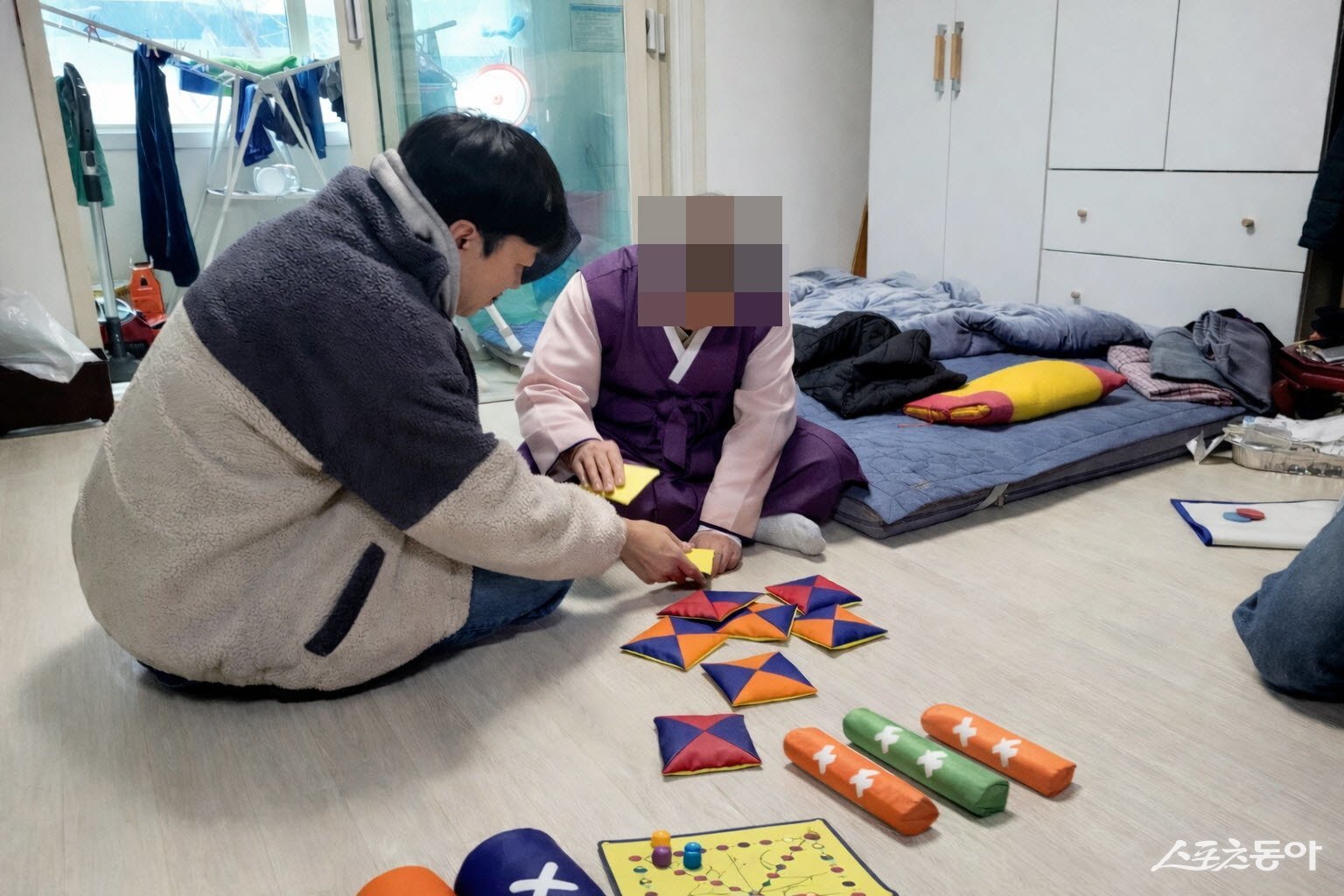 치매 어르신과 후견인이 딱지치기 등 전통놀이를 체험하고 있다. 사진제공|수원시