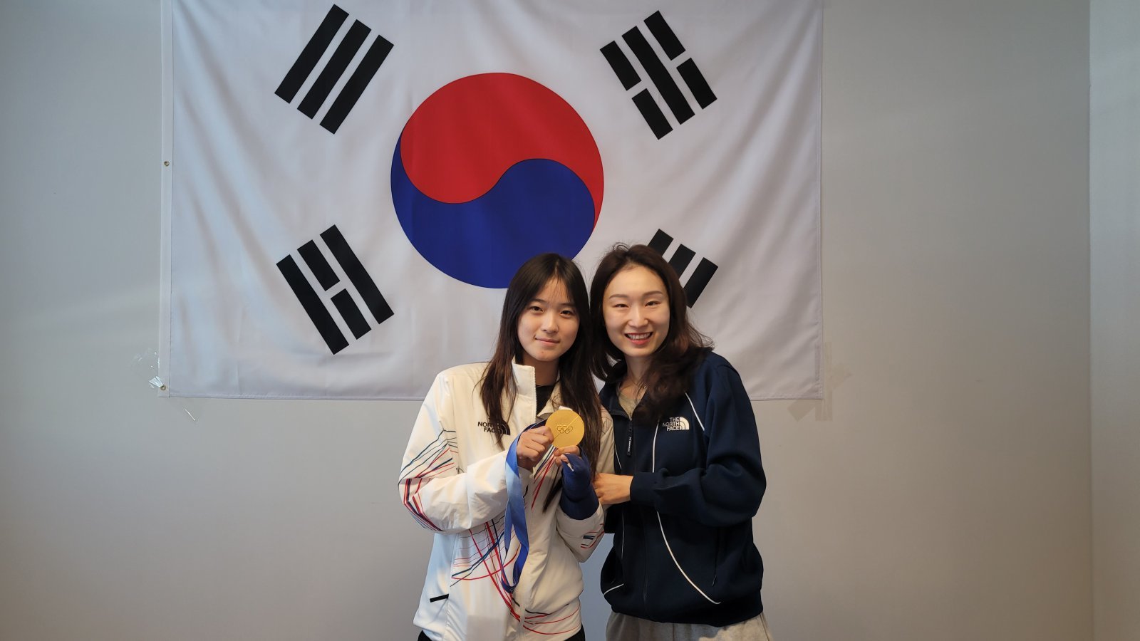 쇼트트랙 대표팀 최민정(오른쪽)과 스노보드 대표팀 최가온이 지난 15일(한국시간) 이탈리아 밀라노 선수촌서 함께 만나 태극기 앞에서 활짝 웃고 있다. 최가온의 금빛 기운을 전달받은 최민정은 19일 열린 쇼트트랙 여자 3000mm 계주에서 금메달을 목에 걸었다. 사진제공｜대한체육회