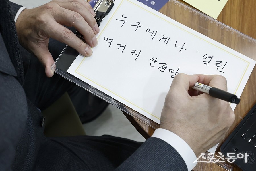 정명근 화성특례시장이 그냥드림 내부 ‘희망나무’에 전시할 메세지를 쓰고 있다. 사진제공｜화성시