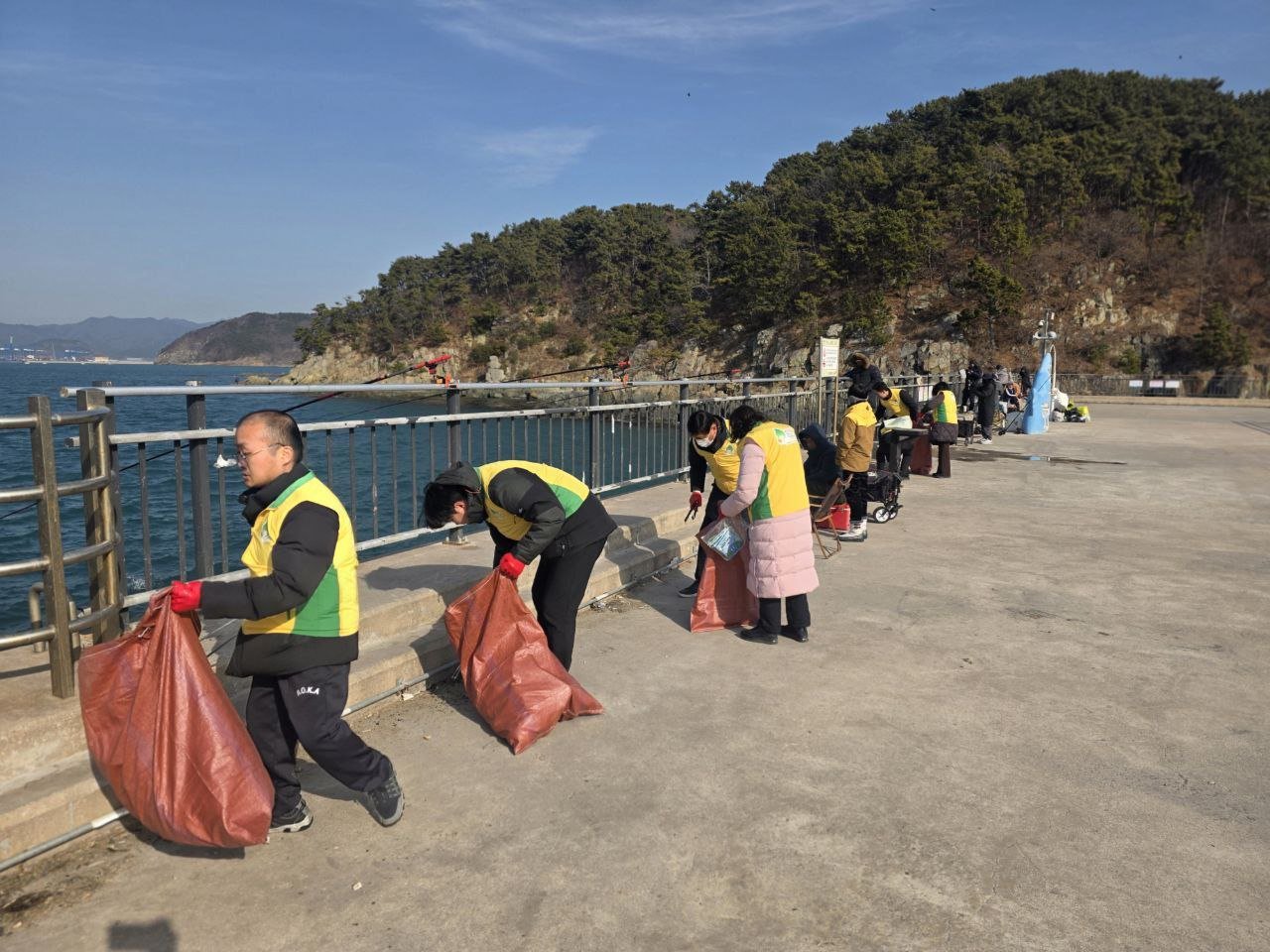 부산경남 민간단체봉사자들이 천성항 방파제 일대에서 생활쓰레기와 폐어구, 각종 플라스틱을 수거하고 있다.